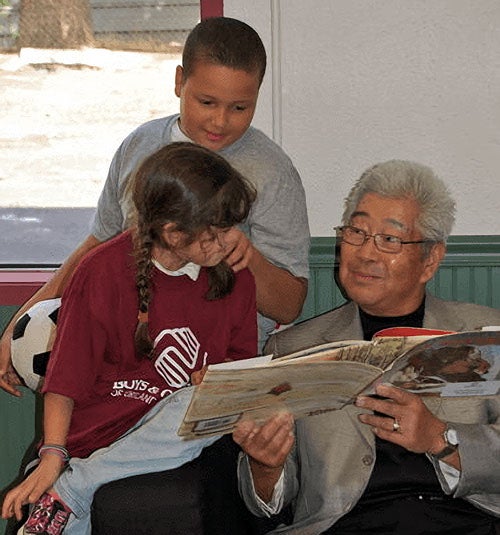 Richard Inukai reading to children